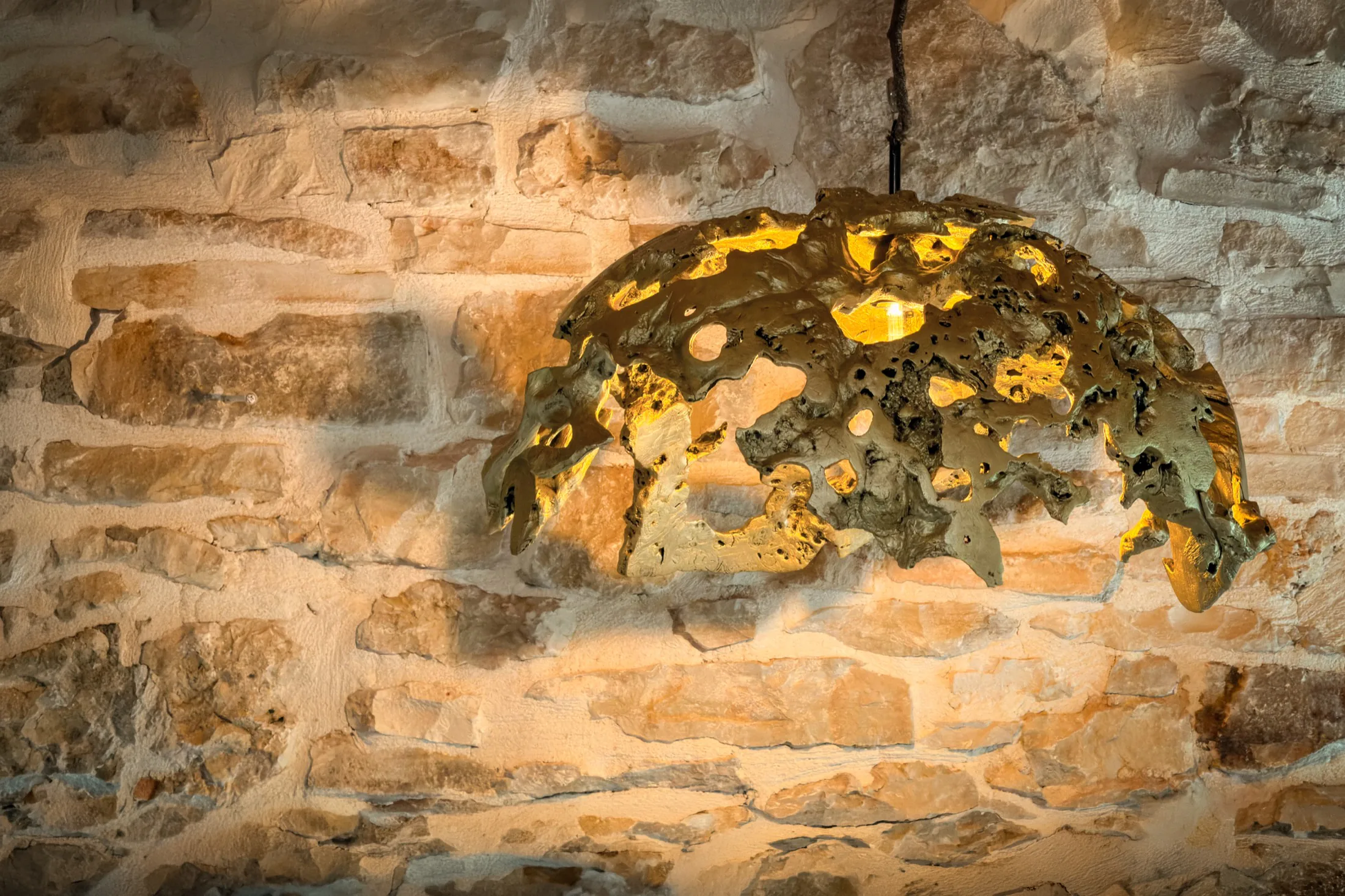 Handcrafted light against a stone wall in the attic